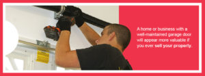 man fixing garage door to increase the value of a home or business